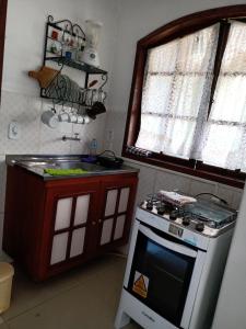 a kitchen with a stove and a sink and a window at Chales do Antonio in São Pedro da Serra +38 photos