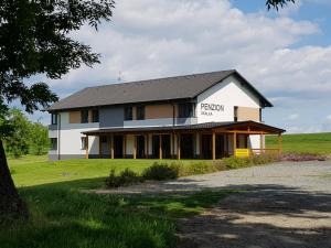 ein großes weißes Haus mit schwarzem Dach in der Unterkunft Penzion Skalka in Skalka