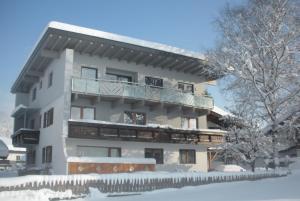 a building with a balcony in the snow at Haus Margit in Kössen