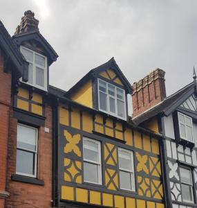 a yellow and black building with white windows at Victoria House in Church Stretton