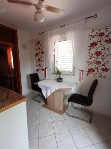 a kitchen with a table and two chairs and a window at Apartments Ivanković in Stari Grad