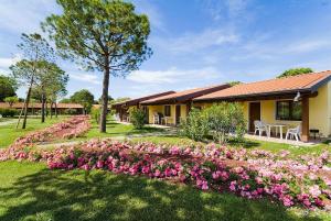 um jardim com flores cor-de-rosa em frente a uma casa em Campeggio del Garda em Peschiera del Garda