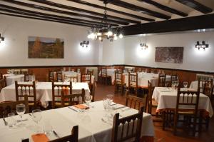 a restaurant with tables and chairs in it at Hostal de Montaña la Casa Grande in Nogueruelas