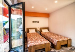 two beds in a room with a glass door at Complex Sportiv Break in Mamaia