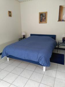 ein blaues Bett mit blauer Decke in einem Schlafzimmer in der Unterkunft Le Rumain in Hengoat