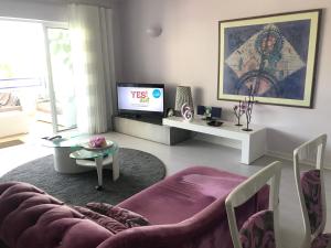 a living room with a couch and a tv at Timeless Vacations Vilamoura Marina Flat WIFI & Pool in Vilamoura