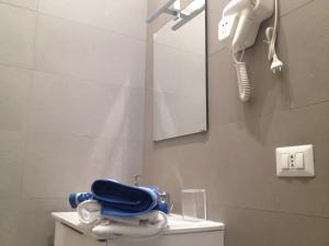 a bathroom with a toilet with a mirror and a phone at Lido Centro B&B in Lido di Ostia