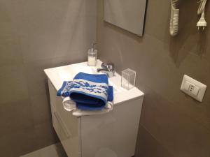a bathroom with a sink and a blue towel at Lido Centro B&B in Lido di Ostia