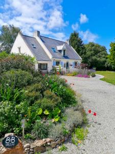 a white house with a garden in front of it at B&B Sarzeau in Sarzeau