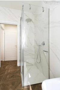 La salle de bains est pourvue d'une douche en verre et de murs blancs. dans l'établissement Madonna Montecchi Luxury Suite in Verona, à Vérone