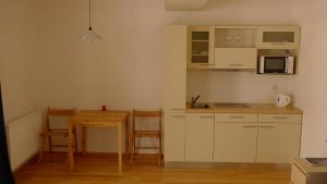 een kleine keuken met een tafel en een magnetron bij Harrachov Apartmán 206 in Harrachov