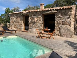 une terrasse avec une piscine, une table et une maison dans l'établissement ALZITEDDA, à Porto-Vecchio