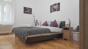 a bedroom with a bed with purple pillows on it at River Center Apartment in Budapest