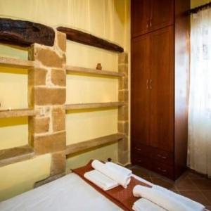 Cette chambre est dotée d'un mur en pierre et d'une table avec des serviettes. dans l'établissement Luxurious Stone Apartment 2, à Kerá