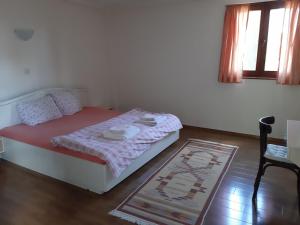 Villa Elen Kamen في ستروغا: غرفة نوم صغيرة بها سرير وسجادة