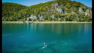 a person on a paddle board in the middle of a lake at Villa Elen Kamen in Struga