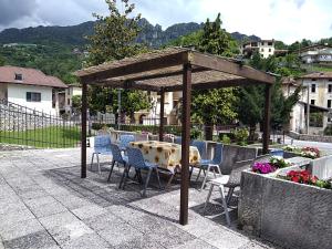un tavolo e sedie sotto un padiglione su un patio di B&B L'Acero a Casto