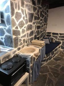 a stone bathroom with a sink and a stove at Angelica in Ano Syros