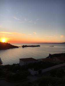 einen Sonnenuntergang über einem Wasserkörper mit Sonnenuntergang in der Unterkunft Tramonto sul mare in Santa Teresa Gallura