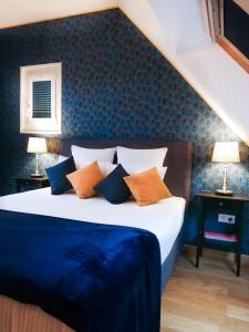 a bedroom with a bed with blue and orange pillows at B&B Sarzeau in Sarzeau