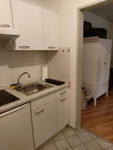 una cocina con armarios blancos y fregadero en 1 Zimmer Appartement Godenblick in Malente en Malente