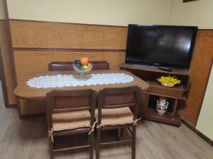 阿內斯的住宿－Ca Victor，小桌子、椅子、桌子和电视