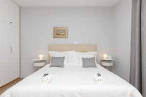 a bedroom with a white bed with two towels on it at Apartman Ružica in Pučišća
