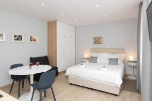 a bedroom with a bed and a table and chairs at Apartman Ružica in Pučišća
