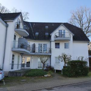 uma casa branca com varandas numa rua em 1 Zimmer Appartement Godenblick in Malente em Malente