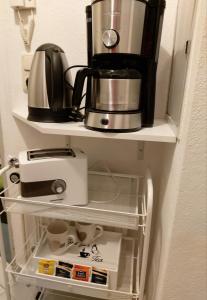 uma cafeteira numa prateleira numa cozinha em 1 Zimmer Appartement Godenblick in Malente em Malente