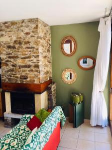 a living room with a stone fireplace and a couch at Gaou Benat, village des fourches, Label patrimoine XXe siècle in Bormes-les-Mimosas