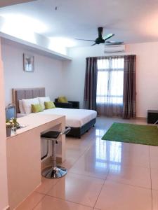 a room with a bed and a kitchen and a couch at Agrima Studio Apartment in Kota Bharu