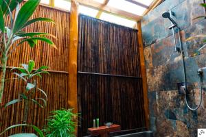 a bathroom with a shower and a wooden wall at Hotel Casa Buenavista - Adults only in Sámara