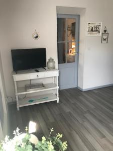 a living room with a television on a white entertainment center at Au cœur de Céreste in Céreste