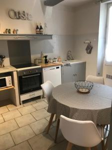 a kitchen with a table and a table and chairs at Au cœur de Céreste in Céreste