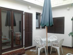 a table and chairs and an umbrella on a patio at Apartments Krpan in Donja Klada +21 photos