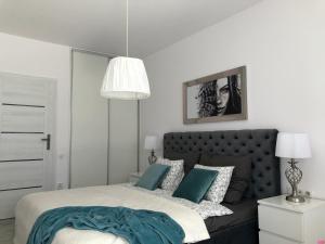 - une chambre avec un lit doté d'oreillers bleus et blancs dans l'établissement Apartament na Leśnej, à Pobierowo