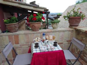 un tavolo con una tovaglia e fiori rossi e bianchi di La Casetta del Muratore a Recanati