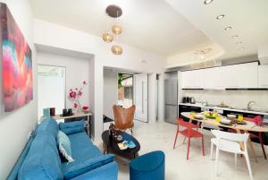 a living room with a blue couch and a kitchen at Elounda Buena Vista Apartment in Elounda