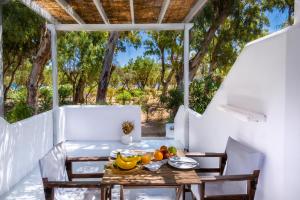 a table on a porch with fruit on it at Coralli Seaside Resort in Livadakia