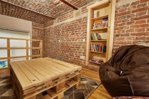 リヴィウにあるShelterの木製テーブルとレンガの壁が備わる客室です。