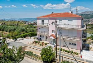 a large white building with a red roof at AAA Anić Amazing Apartments DELUXE in Split