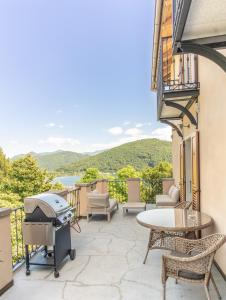 a patio with a grill and a table and chairs at Castellino Bella Vista in Ponte Tresa