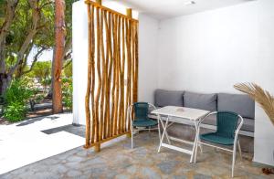 a patio with a table and chairs and a couch at Coralli Seaside Resort in Livadakia