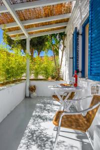 a white patio with a table and chairs on it at Coralli Seaside Resort in Livadakia