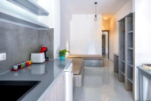a kitchen with gray countertops and a living room at Coralli Seaside Resort in Livadakia