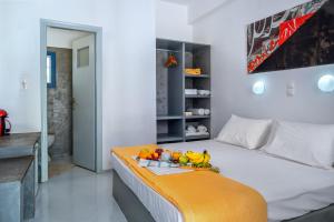 a bedroom with a bed with a tray of fruit on it at Coralli Seaside Resort in Livadakia