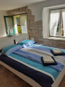 ein großes Bett in einem Schlafzimmer mit zwei Fenstern in der Unterkunft Apartma Fiorina in Sečovlje