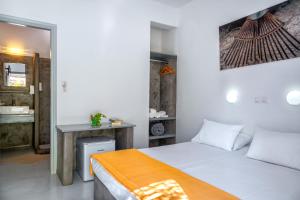a bedroom with a bed and a desk in a room at Coralli Seaside Resort in Livadakia