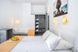 a bedroom with a bed with a bowl of fruit on it at Coralli Seaside Resort in Livadakia